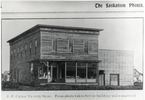Original title:  Courtesy Saskatoon Public Library. Half-tone (screened) image of J.F. Cairns Grocery Store at 2nd Avenue and 21st Street. This view show front and (North) side view of the frame building, which had a glass store front on the main floor. [ca. 1903]