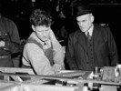 Original title:  Hon. C.D. Howe speaks with a workman at an aircraft factory. 