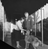 Original title:  Rt.Hon. John George Diefenbaker, Prime Minister of Canada, and Mrs. Olive Diefenbaker with pet dog on door step of official residence, 24 Sussex Drive. 